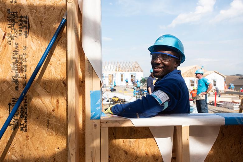 Man in hard hat smiling on build site. 