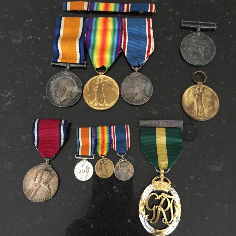 Two rows of First World War medals ranging in color from dark silver to gold honoring Catherine's late father and grandfather.
