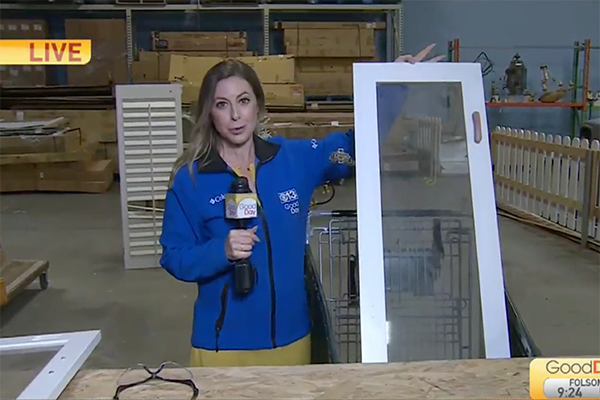 Dina Kupfer, reporter and anchor for Good Day Sacramento, on air, holding up a window pane from a Habitat ReStore.
