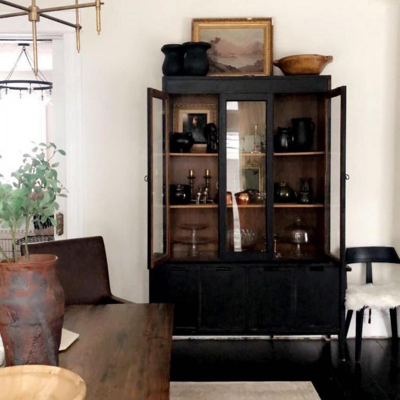 A striking glass cabinet painted black.