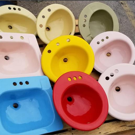 Three rows of of porcelain sinks including pink, red, blue, green and yellow ones.
