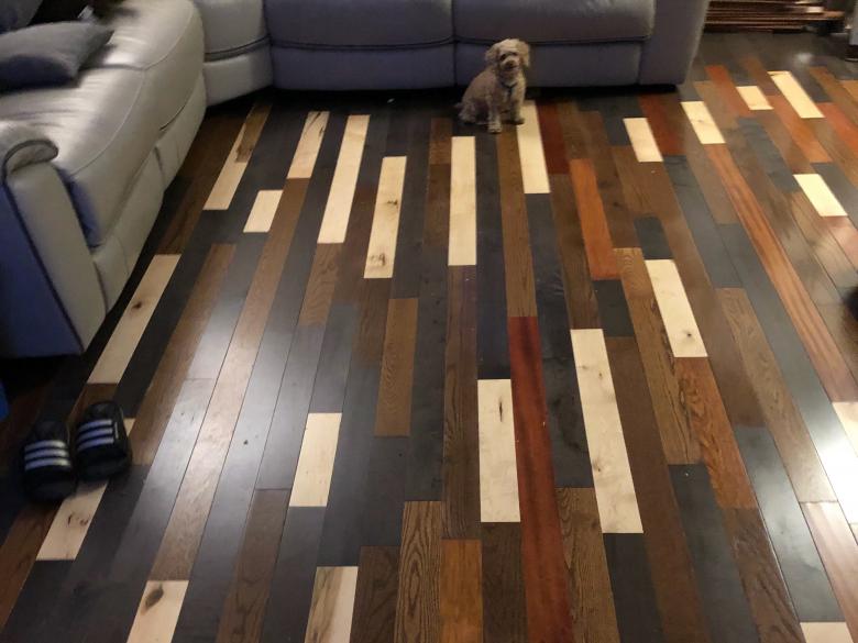 Wood panel flooring with dark brown, black and light colored planks.