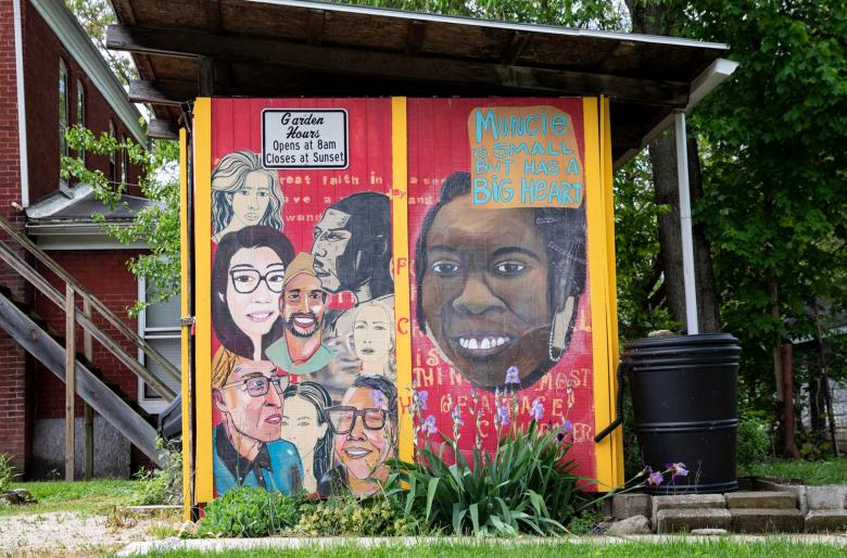 Mural celebrating diversity painted on the side of a community garden shed in Muncie, Indiana.