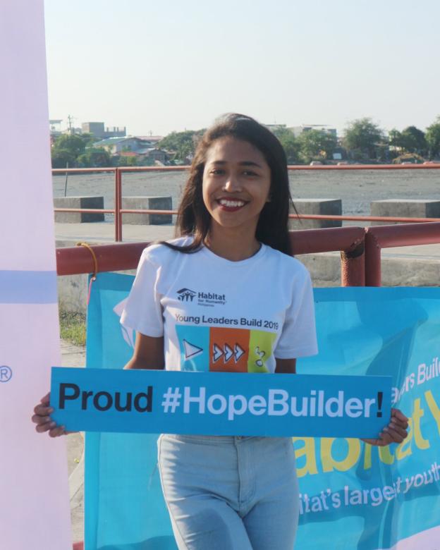Mardee holding a sign that reads "Proud #HopeBuilder!"