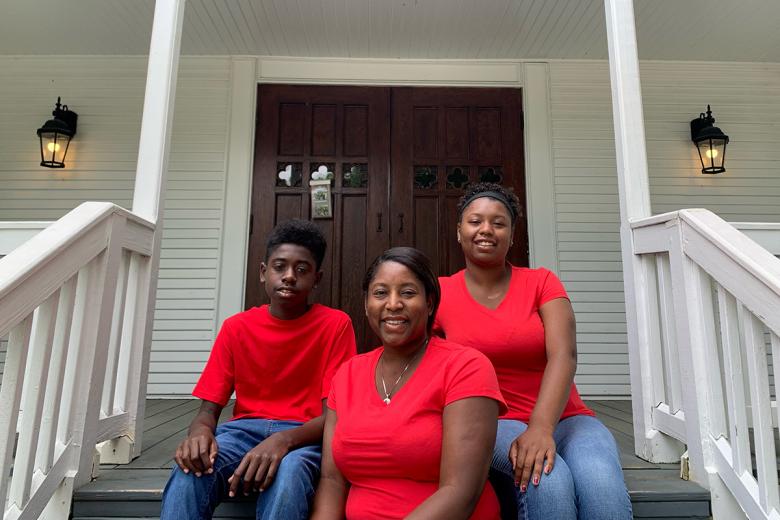 Homeowner Latonia and her children on their home's front stoop.