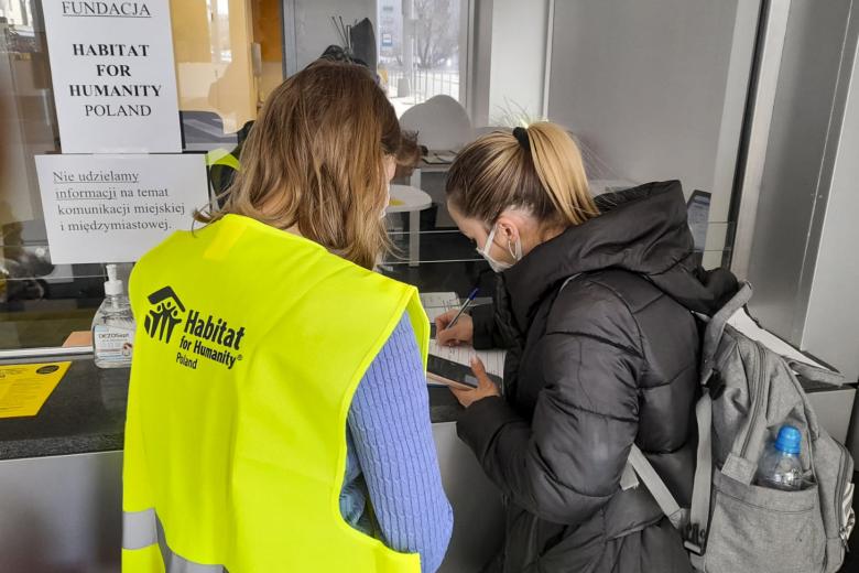 Habitat Poland representative helping Ukrainian refugees sign up for temporary housing.