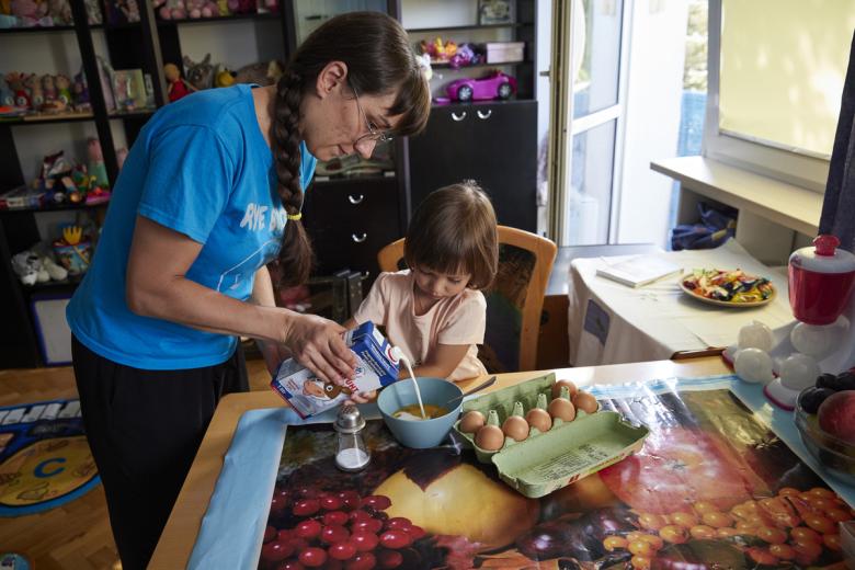 daughter helping her mother prepare a meal