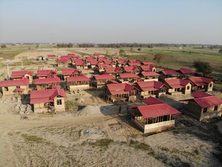 Aerial view of bamboo framed houses with red roofs 