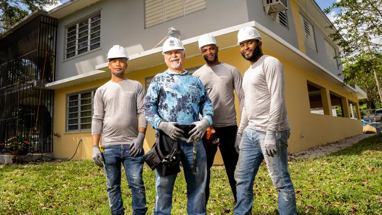 José and his team of three contractors in front of a home repair site.