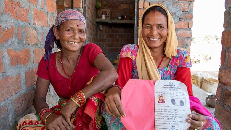 Rupa (right) with her mother Bishna shows her land ownership certificate in Kanchanpur, Nepal