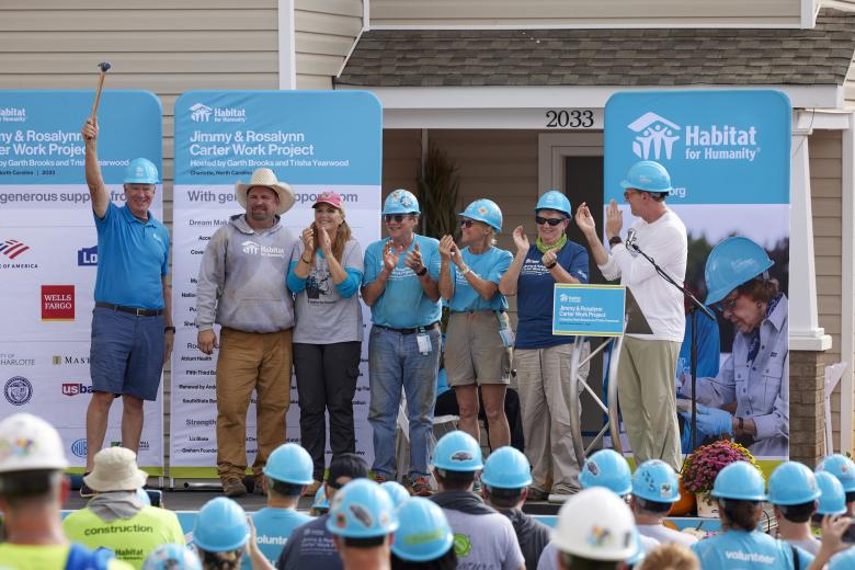 President and CEO Chris Coleman receives the ceremonial hammer on behalf of Twin Cities Habitat for Humanity, host of the 2024 Jimmy & Rosalynn Carter Work Project.