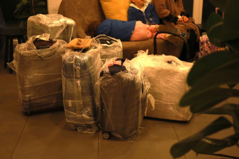 Luggage and kids sleeping in hotel lobby