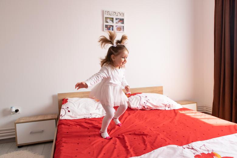 girl jumping on bed