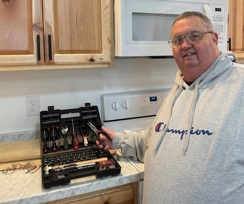Jerry in his new kitchen proudly showing off his homeowner tool kit