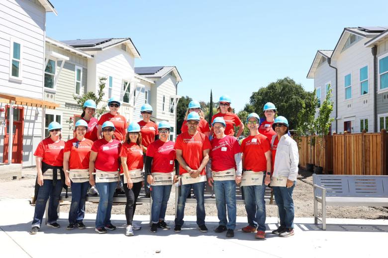Volunteers in front of homes.