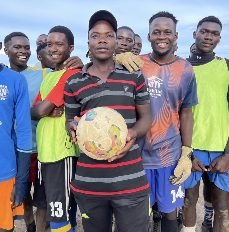 footballers in sport attire pose for a photo
