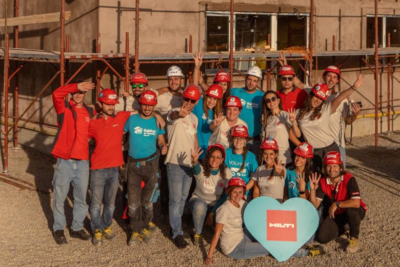 A group of volunteers posing for a picture on the construction site of a Hope Build