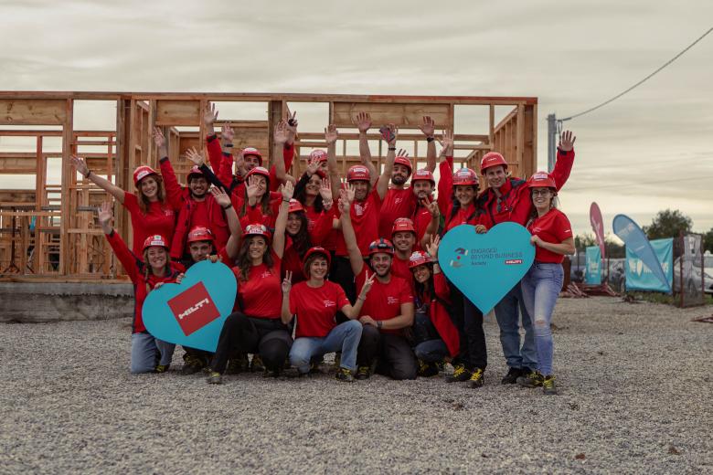 A corporate volunteer group posing for a picture on the construction site