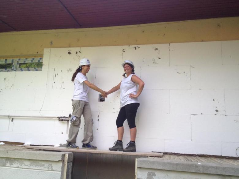 Two volunteers shaking hands on a construction site