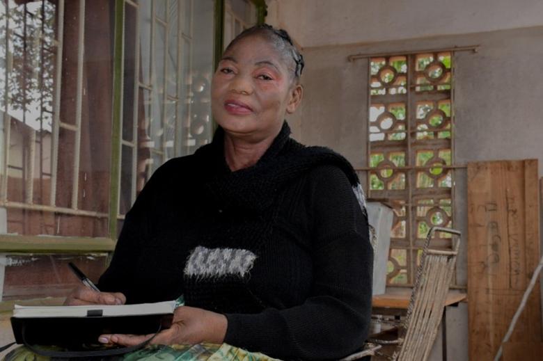 woman holds a clipboard infront of a house