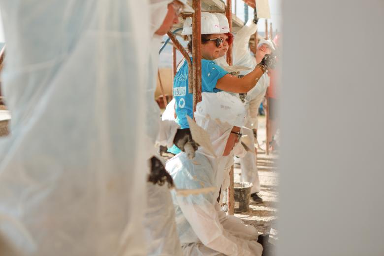 Volunteers working on the siding of the house