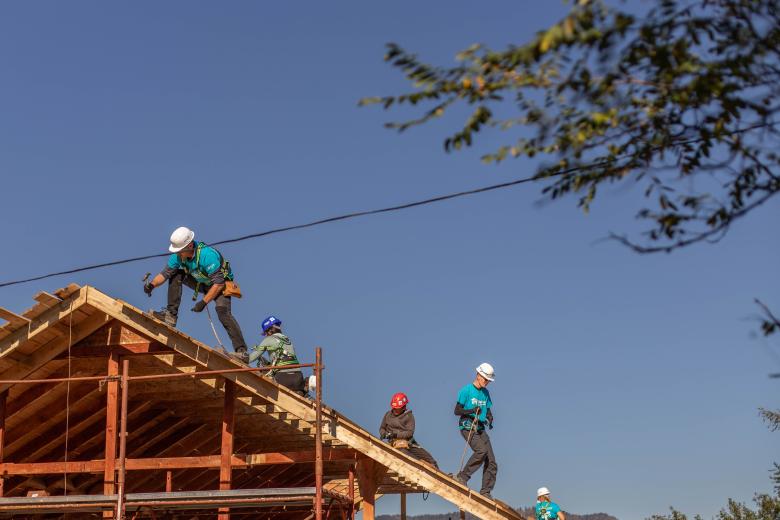 Volunteers working on a rooftop on the construction site