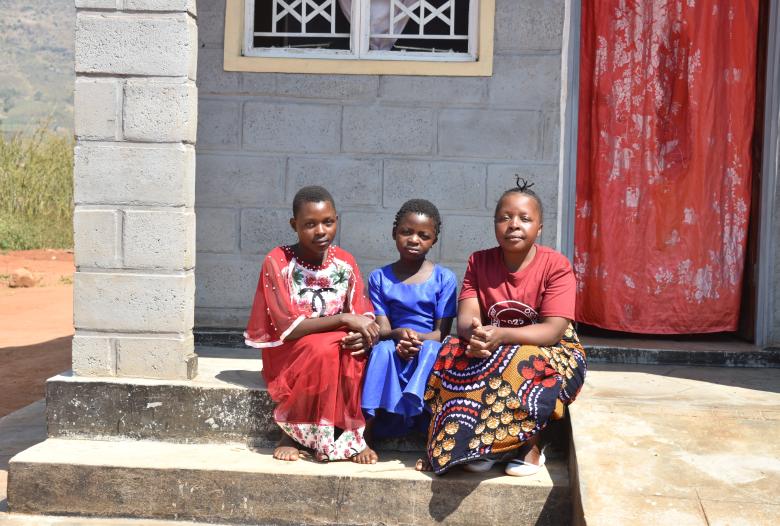 Christina and her daughters outside their home