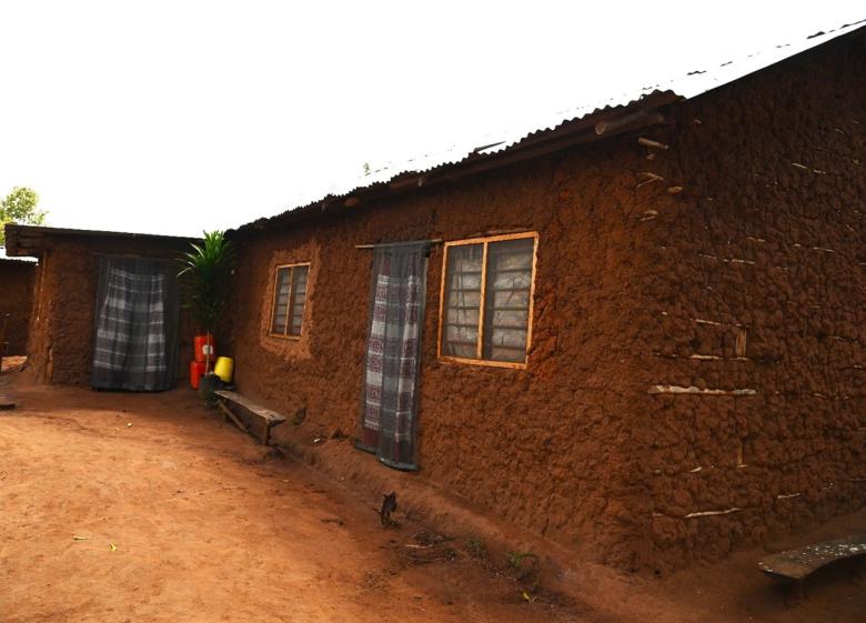 side profile of a mud home with netting on windows and doors