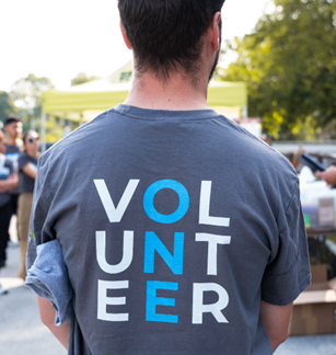A man seen from behind wearing a T-Shirt that says "Volunteer" on the back.