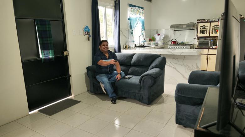 Juan Pablo in the living room of his new home, where he can comfortably watch television.